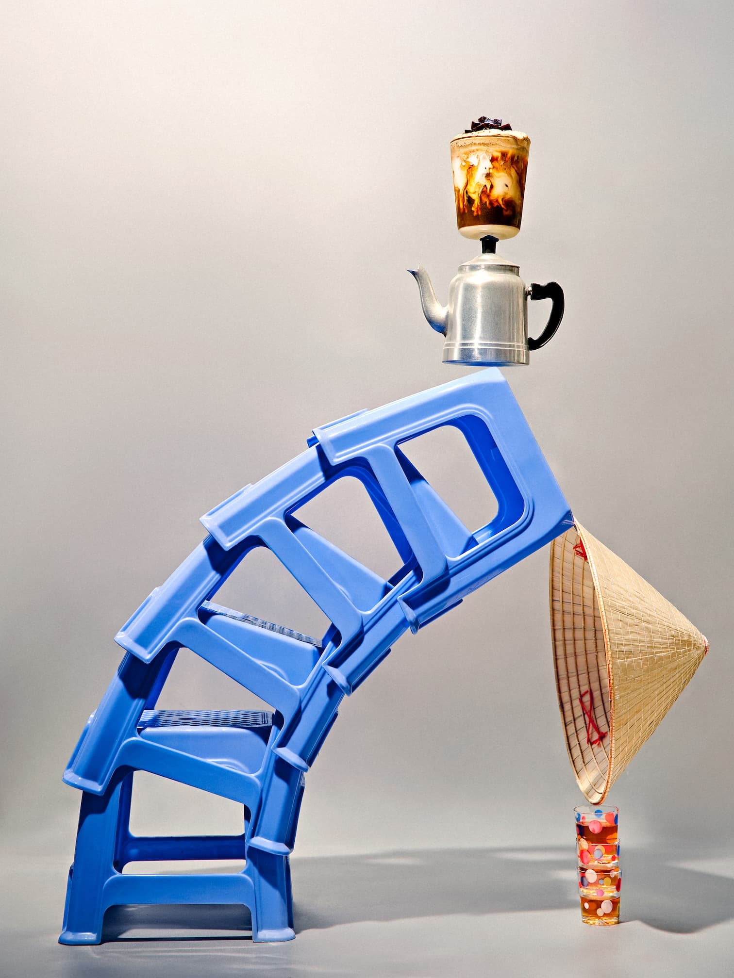 A glass of Trạm egg coffee held up against a clear blue sky